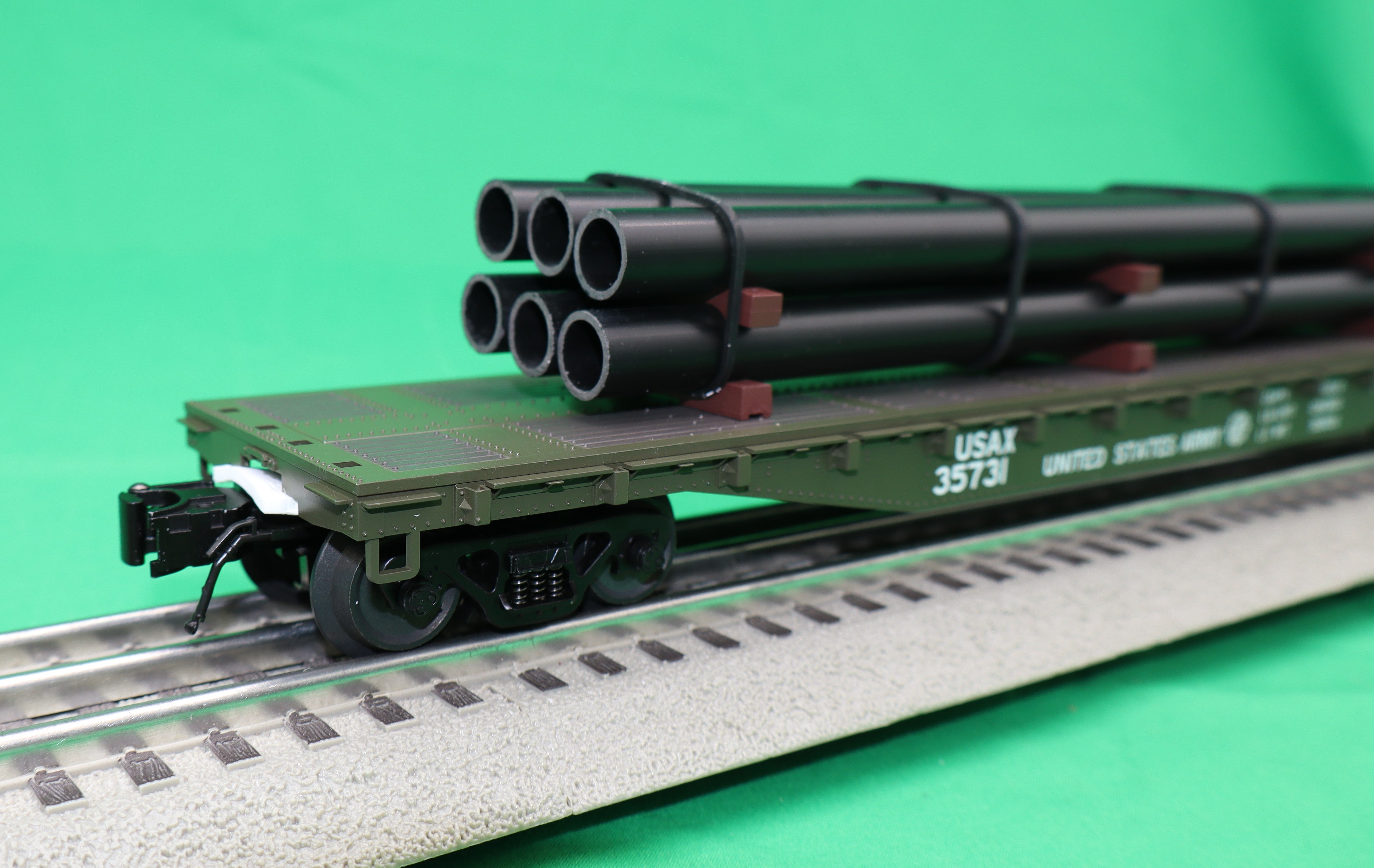 Atlas O 3001887 - Trainman - 52'6" Flat Car "U.S. Army Transportation Corps" (USAX) w/ Pipe Load
