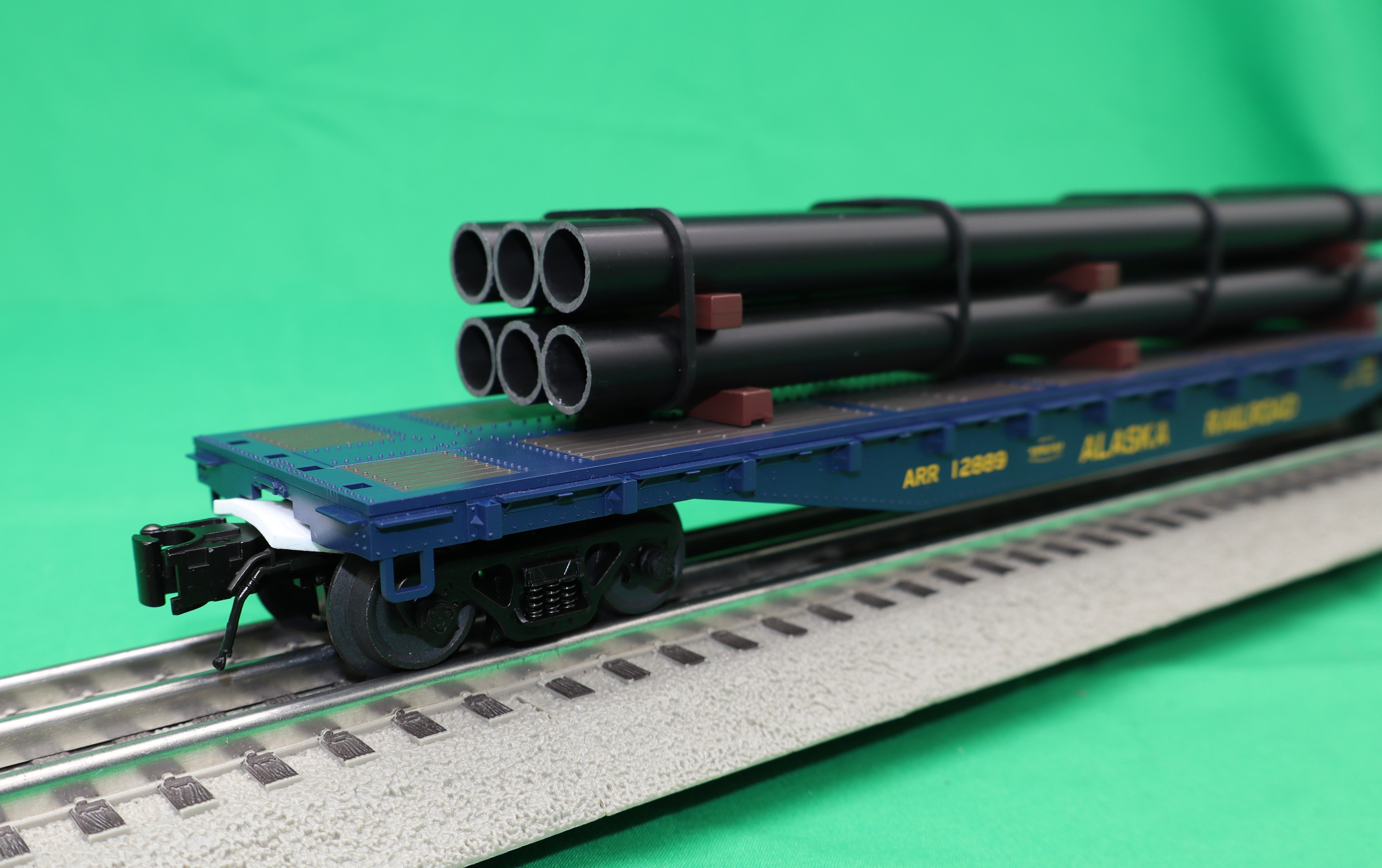 Atlas O 3001880 - Trainman - 52'6" Flat Car "Alaska Railroad" w/ Pipe Load